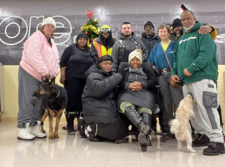 Jay Withey, centro, con personas a las que ayudó a encontrar refugio de la tormenta en Pine Hill School en Cheektowaga, NY