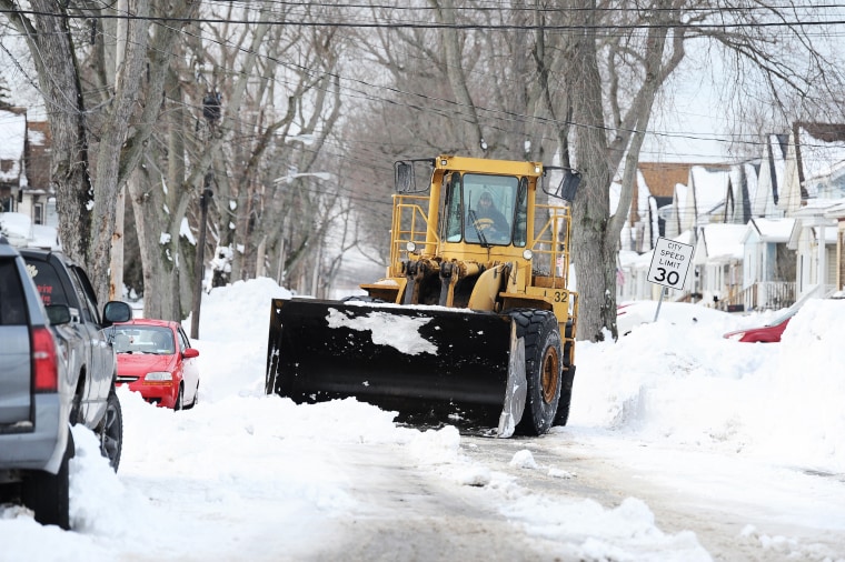 A loader removes snow from a residential street in Buffalo