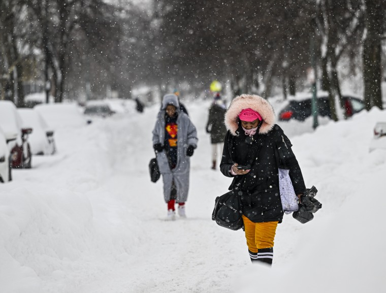 Ciudadanos caminan por la acera cubierta de nieve después de la nevada en Buffalo, Nueva York, el 26 de diciembre de 2022.