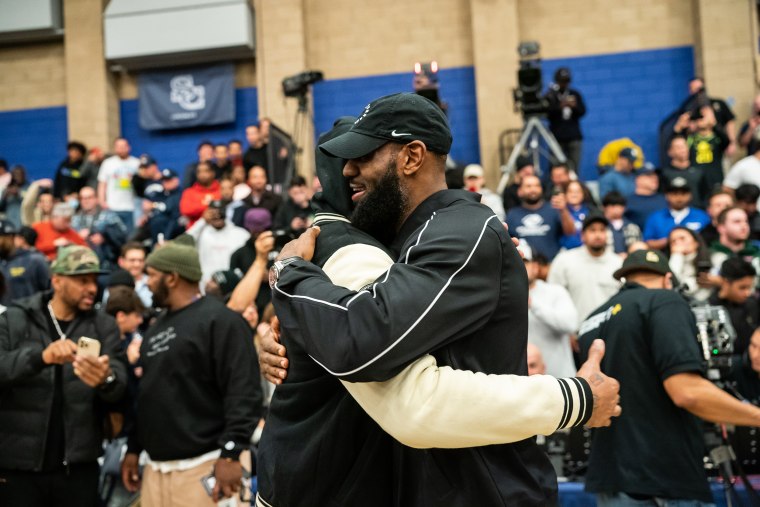 Carmelo Anthony talks to LeBron James at the Sierra Canyon vs Christ The King boys basketball game at Sierra Canyon High School on December 12, 2022 in Chatsworth, California.