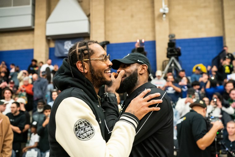 Carmelo Anthony talks to LeBron James at the Sierra Canyon vs Christ The King boys basketball game at Sierra Canyon High School on December 12, 2022 in Chatsworth, California. 
