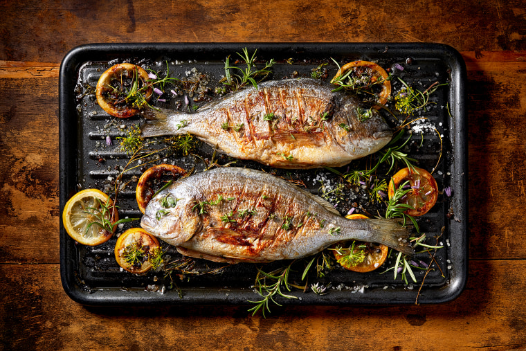 Grilled  fish with the addition of spices, herbs and lemon on the grill plate.