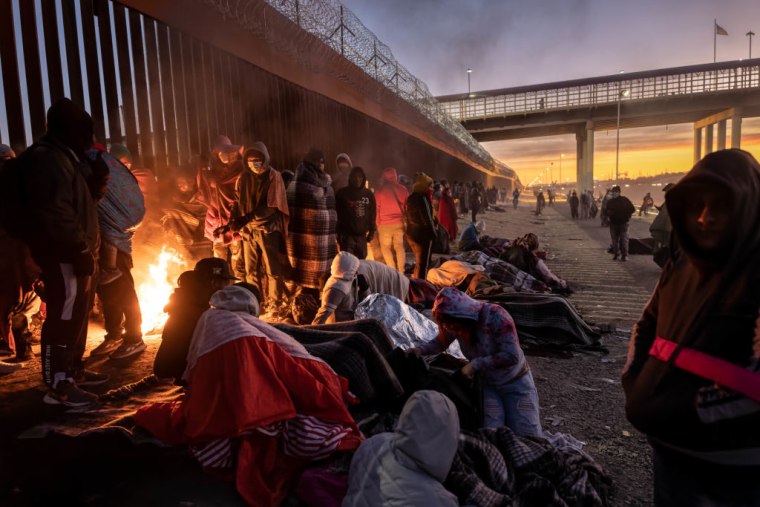 Migrantes en la frontera con México en El Paso, Texas, se mantienen calientes, el 22 de diciembre de 2022.