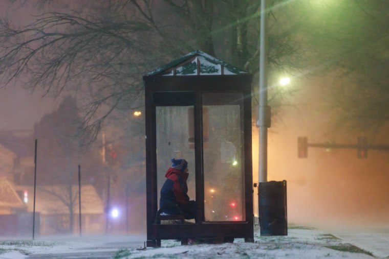 Una persona espera el autobús en una parada de Bloomington, Indiana, el 23 de diciembre de 2022, donde la tormenta redujo la visibilidad.