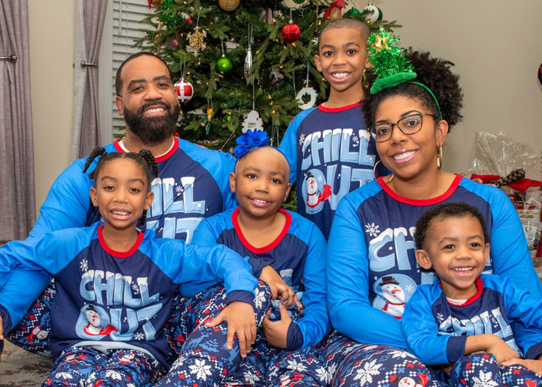 The Edwards family poses for a photo after three family members took the step of cutting off their all their hair.