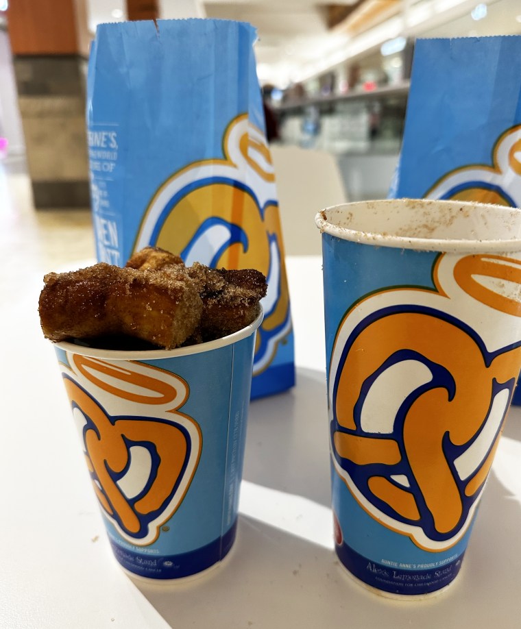 Auntie Anne's Cinnamon Sugar Pretzel Nuggets overflowing out of the cup. There are still some in the large cup that wouldn't fit.