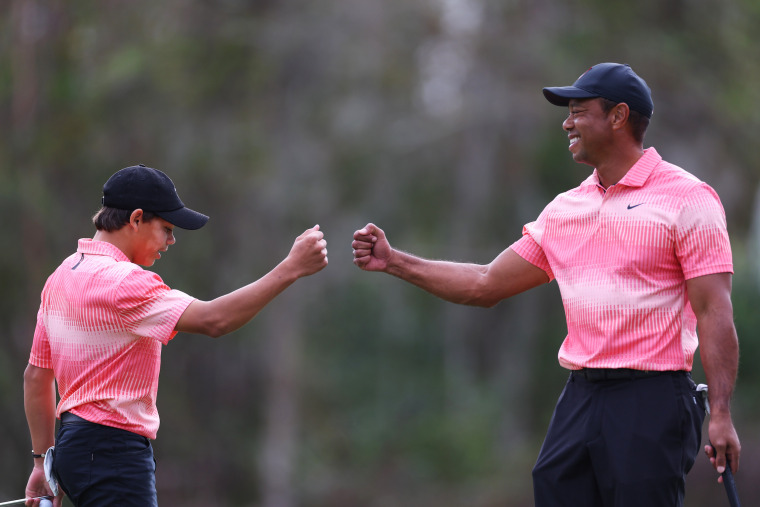 Tiger Woods and his son bumping fists during the tournament.