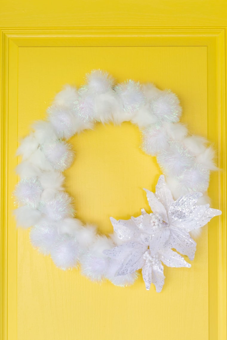 fluffy white winter wreath with poinsettia 