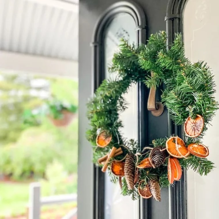 green wreath with dried oranges and pinecones