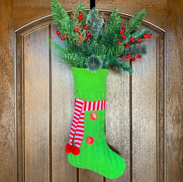 green knit stocking full of faux greenery