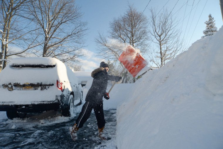 Una mujer limpia la nieve en Nueva York en una foto de noviembre 2022.