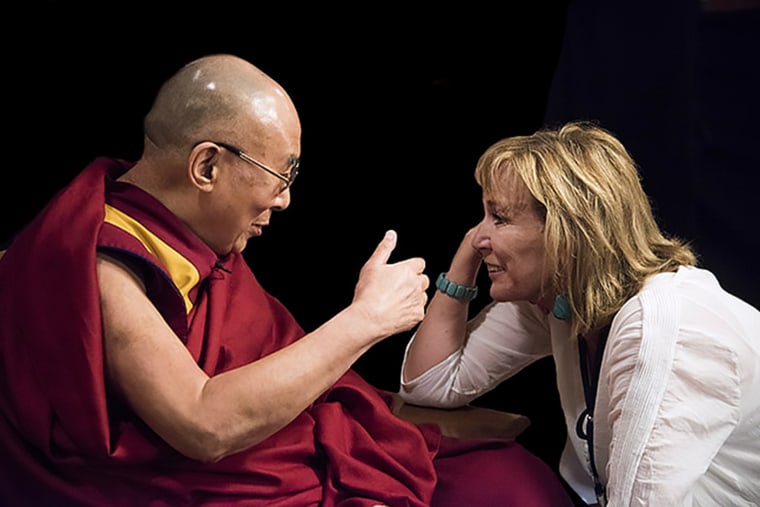 Filmmaker Peggy Callahan leans in during a discussion with the Dalai Lama.