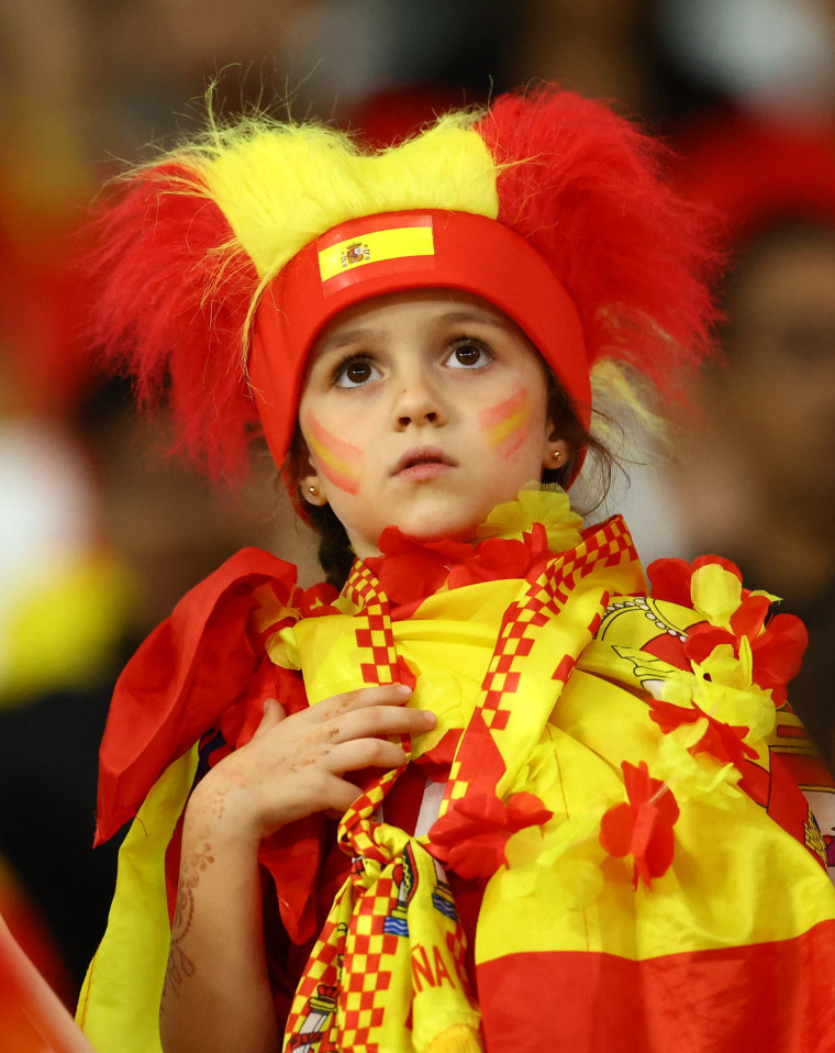 Una niña viste un traje completo con los colores de la selección española. 