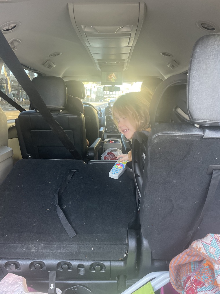 Chelsea Long's daughter, in the back of their neighbor's van waiting for her dad to find their 10 pieces of luggage after their Christmas Eve flight was canceled.