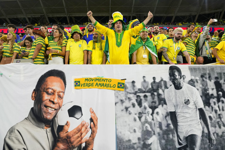 Aficionados de Brasil alientan a la selección detrás de un cartel con imágenes de Pelé, el lunes 5 de diciembre de 2022, antes del partido ante Corea del Sur en Al Rayán, Catar.