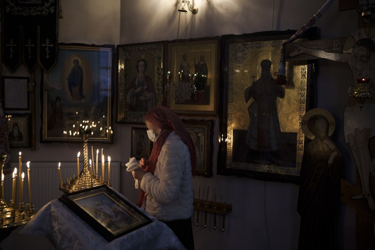 Una mujer asiste a una misa de Navidad en una iglesia ortodoxa en Bobrytsia, en las afueras de Kiev, Ucrania, el domingo 25 de diciembre de 2022.