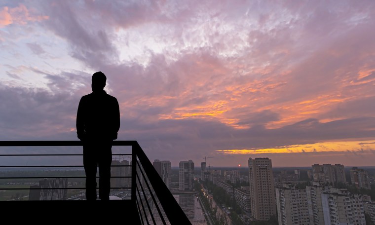 The man standing on the balcony on the big city background
