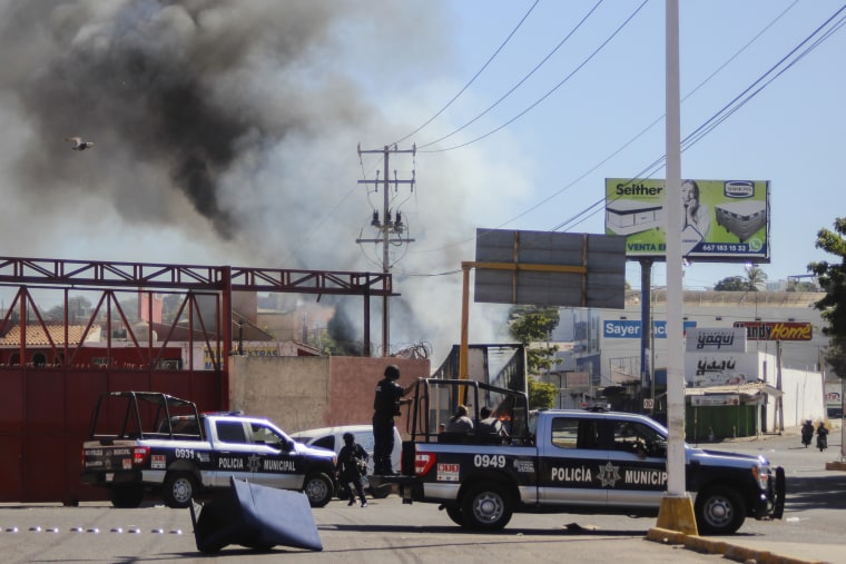 Police arrive on the scene after a store was looted in Culiacan, Mexico