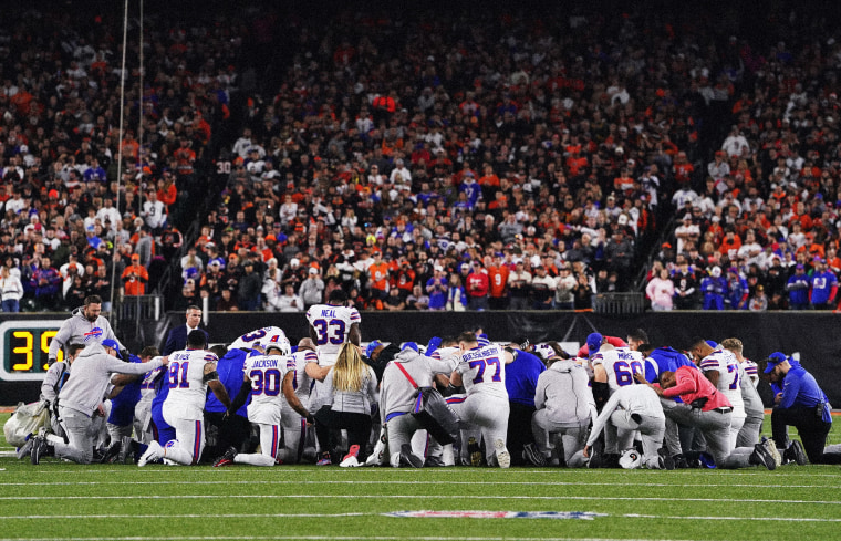Image: Buffalo Bills players and staff take a knee after their teammate, Damar Hamlin, collapsed on the field during a game against the Cincinnati Bengals at Paycor Stadium on Jan. 2, 2023.
