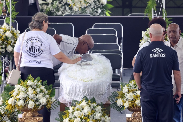 A mourner kisses Pele's head at his wake at the Urbano Caldeira Stadium in Santos, Brazil.