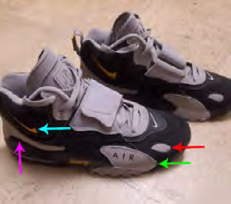         La persona vestía zapatillas Nike Air Max Speed ​​Turf negras y gris claro con un logo amarillo. 