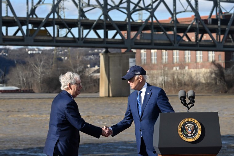 US President Joe Biden (R) shakes hands with Senate Minority Leader Mitch McConnell during an event about the bipartisan infrastructure law in front of the Brent Spence Bridge in Covington, Kentucky, on January 4, 2023.