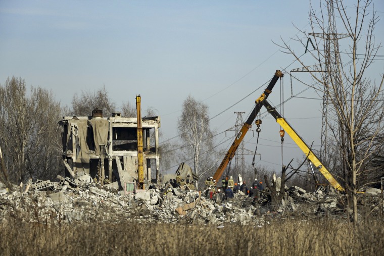 Workers clear rubble after a Ukrainian rocket strike in Makiivka, Ukraine