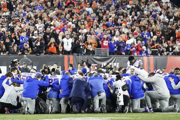 Buffalo Bills players and staff pray for Buffalo Bills' Damar Hamlin during a game against the Cincinnati Bengals in Cincinnati