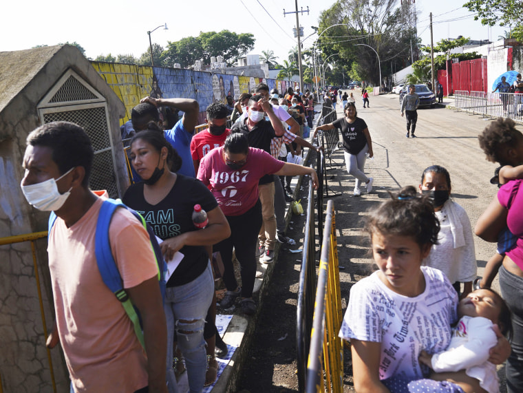 Migrants wait in line outside the National Immigration Institute