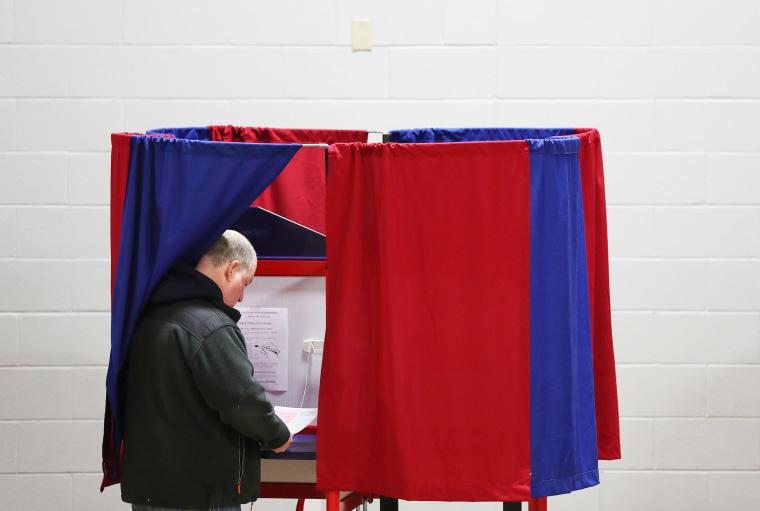 A voter prepares to cast their ballot at a polling station during the 2020 presidential primary in Manchester, N.H. 