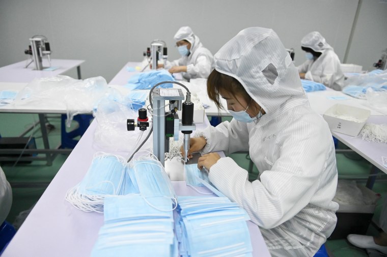 Çin'in Liaoning Eyaleti, Shenyang'da 16 Mayıs 2020'de koronavirüs salgını sırasında tüm zamanların en yüksek seviyesinde denizaşırı maske siparişleri olarak yüz maskeleri üretmeye başlayan bir eldiven fabrikasında çalışanlar, bir üretim hattında yüz maskeleri yapıyor.