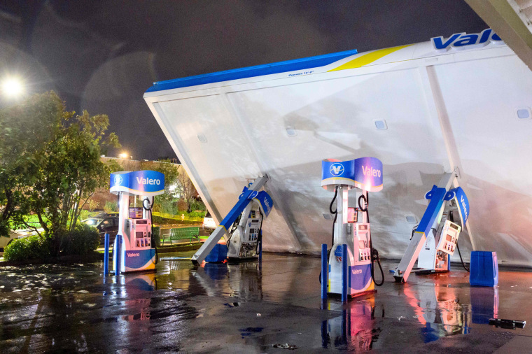 A damaged Valero gas station creaks in the wind during a "bomb cyclone" rain storm
