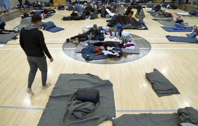 Migrants rest at a makeshift shelter Friday in Denver. Over the past month, nearly 4,000 immigrants, almost all Venezuelans, have arrived unannounced in the frigid city, with nowhere to stay and sometimes wearing T-shirts and flip-flops.