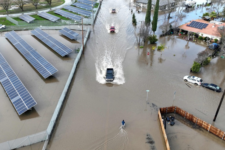 Los automóviles circulan por una carretera inundada en Planada, California, el 10 de enero de 2023.