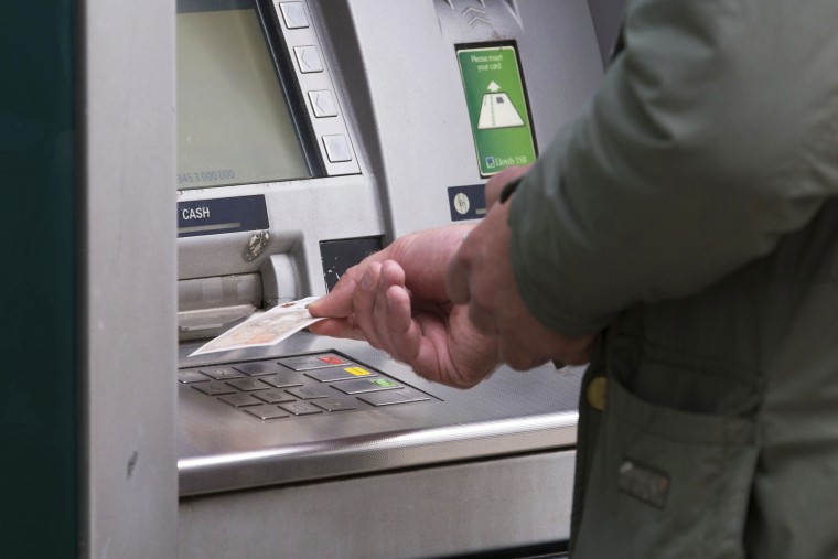 A man withdraws money from an ATM