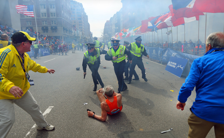 Police officers with their guns drawn hear a second explosion at the finish line of the Boston Marathon on April 15, 2013.