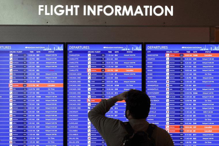 A traveler looks at a flight information board at Ronald Reagan Washington National Airport on January 11, 2023 in Arlington, Virginia. The FAA said it is gradually resuming flights around the country after an outage to the Notice to Air Mission System, a computer system that helps guide air traffic.