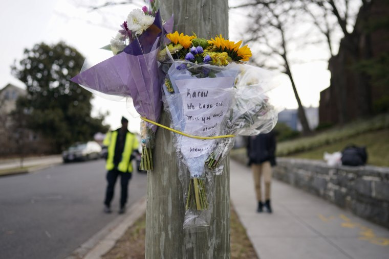 Atan flores a un poste en memoria de Karon Blake en el barrio de Brookland