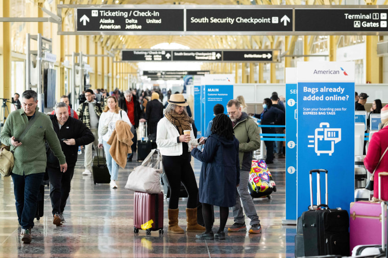 Travelers walk through a terminal at Ronald Reagan Washington National Airport