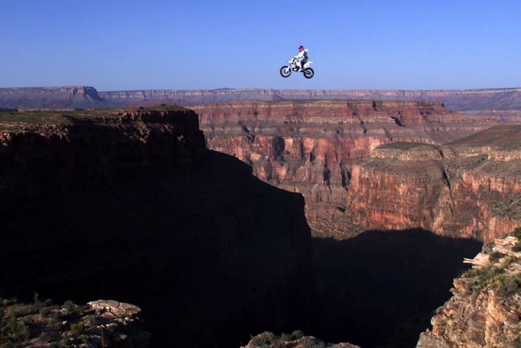 Robbie Knievel of the US is airborne above the Grand Canyon, AZ, 20 May, 1999 during a successful 228 feet (some 68 meters) world record jump. Knievel crashed following his landing and sustained unknown injuries but talked to the crowd before being flown by helicopter to the University Medical Center in Las Vegas, NV. AFP PHOTO John Gurzinski