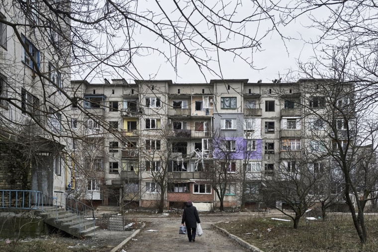 A civilian walks among heavily damaged residential buildings in Soledar, Ukraine