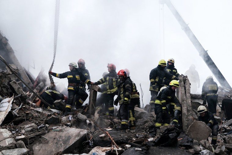 Emergency workers search the remains of a residential building that was struck by a Russian missile yesterday on Jan. 15, 2023, in Dnipro, Ukraine.