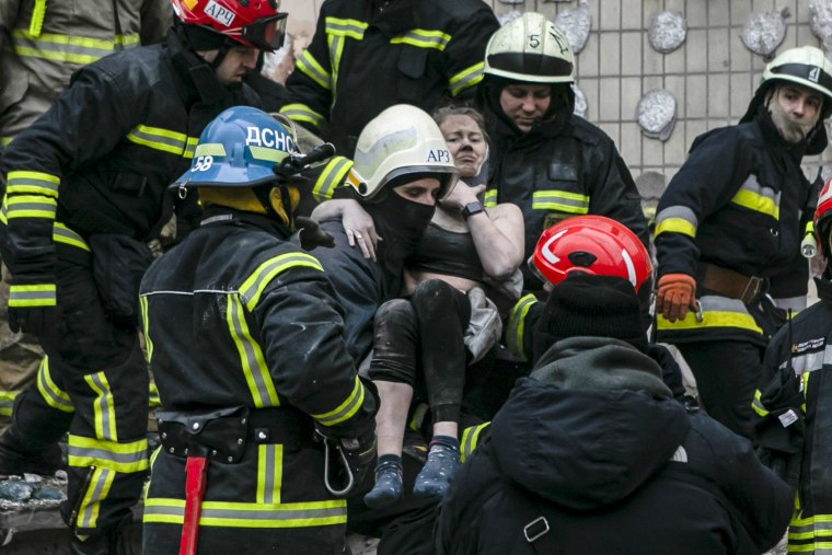 Emergency workers carry a wounded woman after a Russian rocket hit a multistory building on Saturday in Dnipro, Ukraine, on Jan. 15, 2023.
