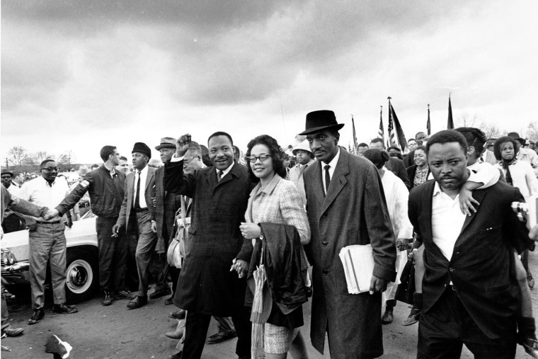 Dr. Martin Luther King Jr., and his wife, Coretta Scott King, lead off the final lap to the state capitol at Montgomery, Ala., on March 25, 1965.  Thousands of civil rights marchers joined in the walk, which began in Selma, Ala., on March 21, demanding voter registration rights for blacks. Rev. D.F. Reese, of Selma, is at right.  (AP Photo)