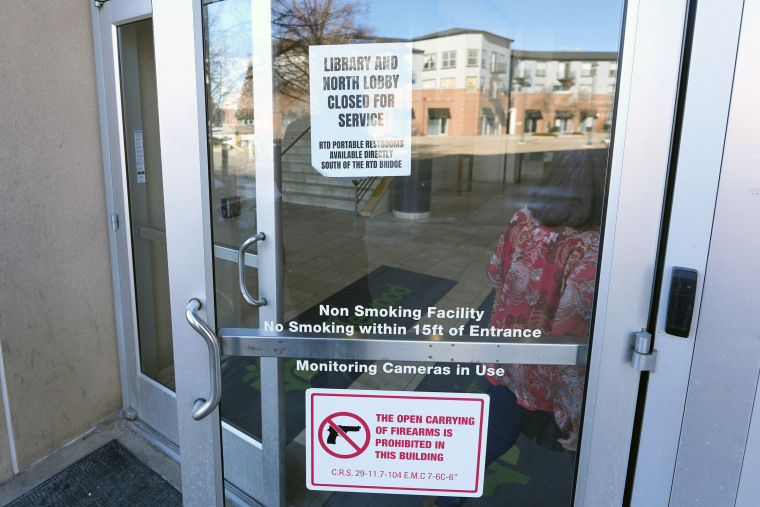 Signs are placed on the outside doors of city hall to advise visitors that the library as well as a restroom are closed because of meth contamination Thursday, Jan. 12, 2022, in the south Denver suburb of Englewood, Colo.