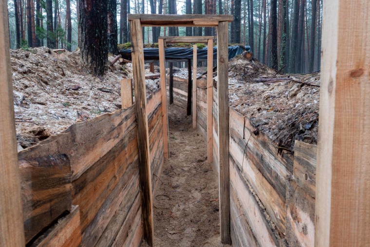 The smell of sawdust fills the air as Ukrainians build trenches on the border with Belarus.