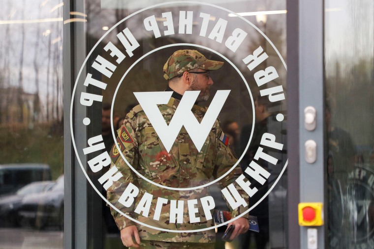 A man wearing a camouflage uniform walks out of PMC Wagner Centre, which is a project implemented by the businessman and founder of the Wagner private military group Yevgeny Prigozhin, during the official opening of the office block in Saint Petersburg, R