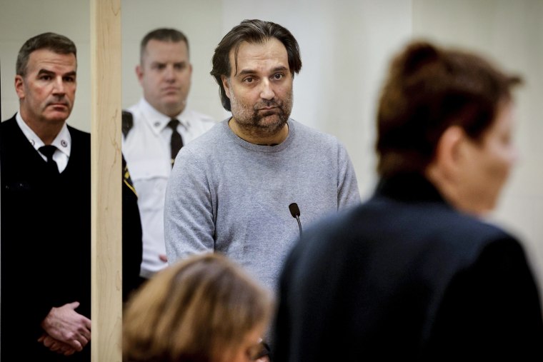 Image: Brian Walshe, center, listens during his arraignment on Jan. 18, 2023, at Quincy District Court, in Quincy, Mass., on a charge of murdering his wife Ana Walshe.