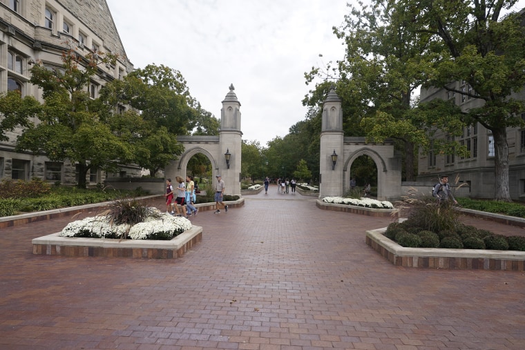 Students walk to classes on the Indiana University campus in Bloomington, Ind