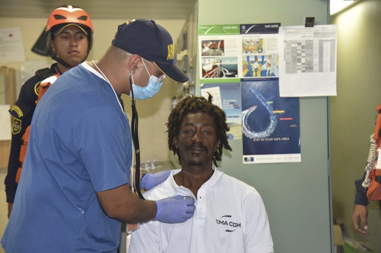 After his rescue, Elvis Francois is examined by a Colombian Navy member on board the merchant ship CMA CGM Voltario at the port of Cartagena, Colombia, on Jan. 16, 2023.